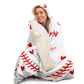 A white hooded blanket featuring red stitching designed to look like a baseball, with small red hearts scattered throughout woman smiling